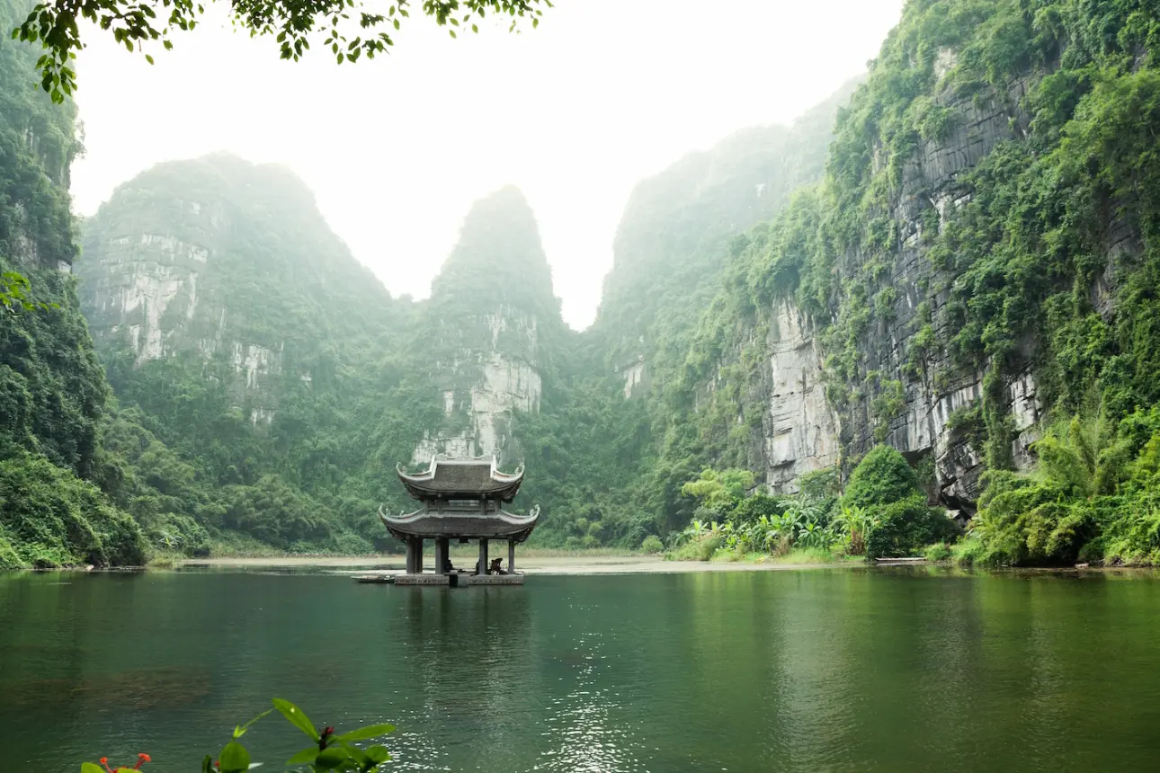Pagoda surrounded by water and limestone karst at Ninh Binh